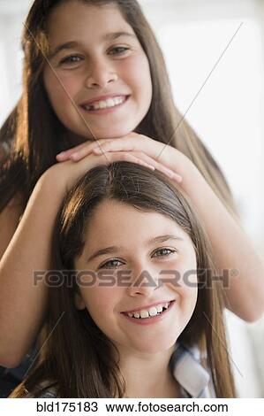 Stock Image - Caucasian twin sisters smiling. Fotosearch