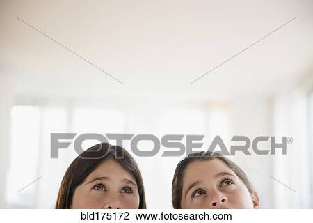 Stock Image - Caucasian twin sisters thinking. Fotosearch