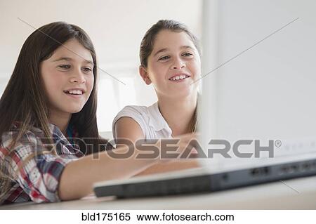 Caucasian twin sisters using laptop View Large Photo Image Stock Photography - Caucasian twin sisters using laptop. Fotosearch
