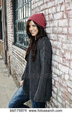 Picture - Caucasian woman leaning on brick wall. Fotosearch