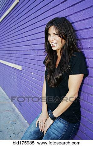 Stock Photography - Caucasian woman leaning on brick wall. Fotosearch