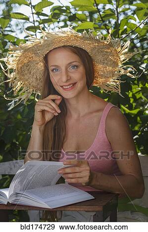 Stock Photo - Caucasian woman reading book outdoors. Fotosearch