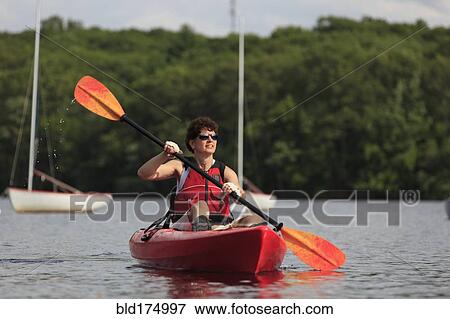 Stock Photo - Caucasian woman rowing kayak. Fotosearch