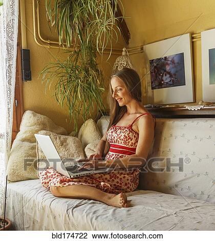 Caucasian woman using laptop on sofa View Large Photo Image Stock Image - Caucasian woman using laptop on sofa. Fotosearch