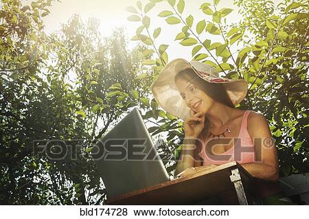 Stock Photo - Caucasian woman using laptop outdoors. Fotosearch