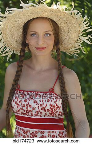 Stock Image - Caucasian woman wearing straw hat. Fotosearch