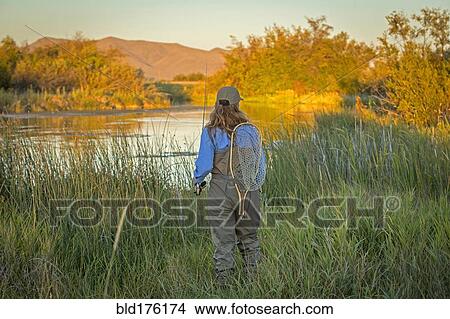 Picture - Caucasian woman with fishing gear at river. Fotosearch