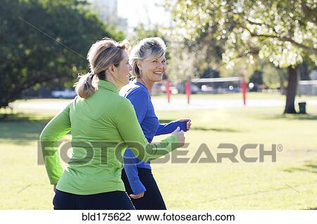 Stock Image - Caucasian women jogging in park. Fotosearch