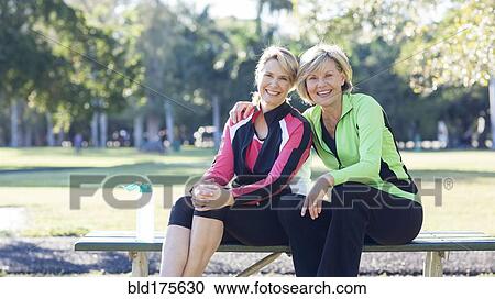 Caucasian women sitting on picnic table in park View Large Photo Image Stock Image - Caucasian women sitting on picnic table in park. Fotosearch