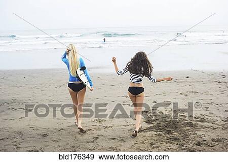 Stock Photo - Caucasian women walking on beach. Fotosearch