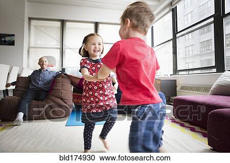 Stock Image - Children dancing in living room. Fotosearch