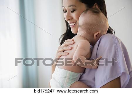 Stock Photo - Chinese nurse holding baby. Fotosearch