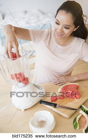 Stock Photography - Chinese woman blending watermelon. Fotosearch