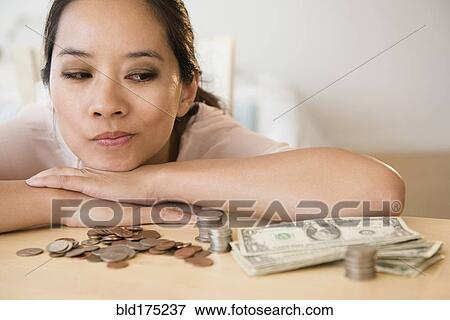 Stock Photo - Chinese woman contemplating finances. Fotosearch