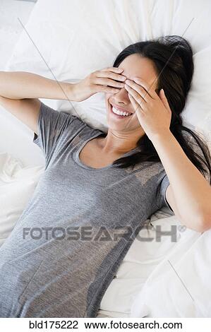 Stock Image - Chinese woman covering her eyes. Fotosearch
