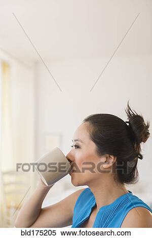Stock Photography - Chinese woman drinking cup of coffee. Fotosearch