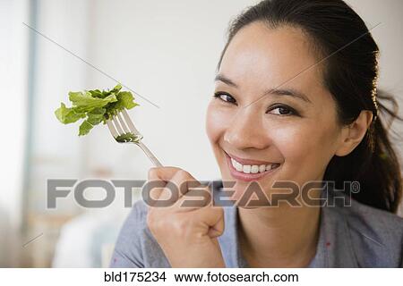 Chinese woman eating salad View Large Photo Image Picture - Chinese woman eating salad. Fotosearch