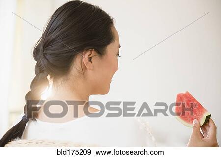 Stock Photo - Chinese woman eating watermelon. Fotosearch