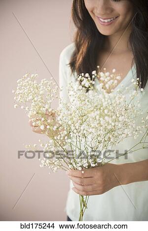 Picture - Chinese woman holding bunch of flowers. Fotosearch