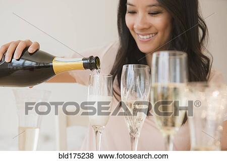 Stock Photo - Chinese woman pouring champagne. Fotosearch