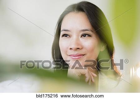 Chinese woman smiling with chin in hand View Large Photo Image Stock Photograph - Chinese woman smiling with chin in hand. Fotosearch