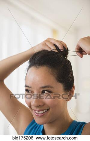 Chinese woman tying her hair in bun View Large Photo Image Stock Photograph - Chinese woman tying her hair in bun. Fotosearch