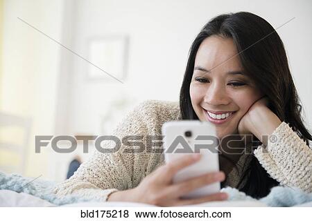 Stock Photo - Chinese woman using cell phone. Fotosearch