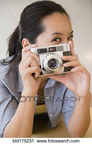 Stock Image - Chinese woman using vintage camera. Fotosearch