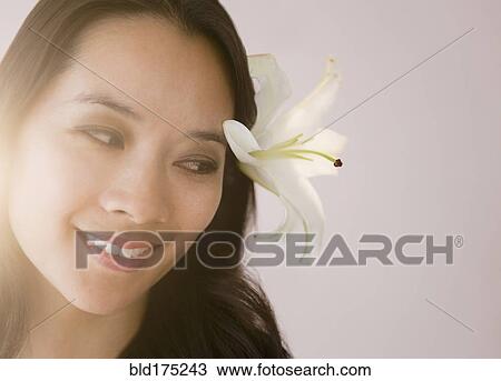 Stock Image - Chinese woman wearing flower in her hair. Fotosearch