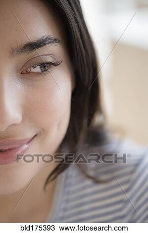 Stock Image - Close up of face of smiling Hispanic woman. Fotosearch