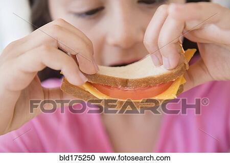 Stock Image - Close up of girl eating sandwich. Fotosearch