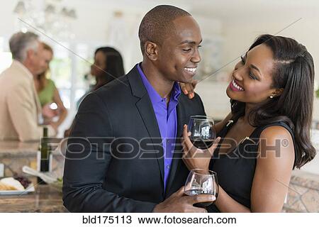 Stock Image - Couple drinking wine at party. Fotosearch