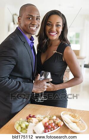 Stock Image - Couple enjoying wine and appetizers. Fotosearch