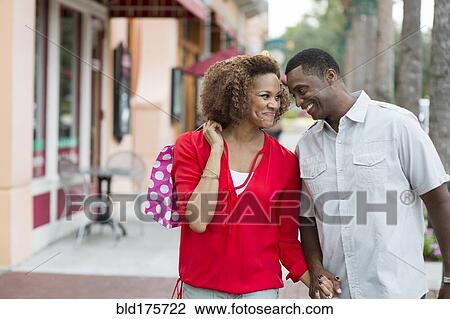 Stock Image - Couple holding hands outdoors. Fotosearch