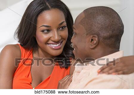 Stock Photo - Couple hugging on sofa. Fotosearch