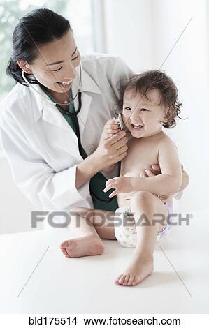 Picture - Doctor and baby girl playing with stethoscope. Fotosearch
