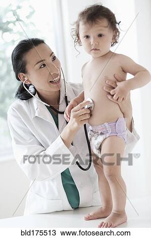 Doctor listening to stomach of baby girl View Large Photo Image Stock Image - Doctor listening to stomach of baby girl. Fotosearch
