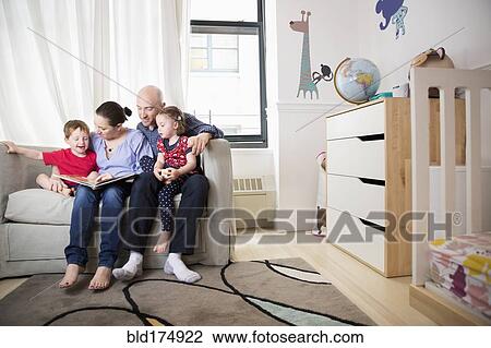 Family reading book on sofa in bedroom View Large Photo Image Stock Image - Family reading book on sofa in bedroom. Fotosearch