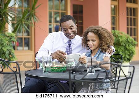 Father and daughter eating at outdoor restaurant table View Large Photo Image Stock Image - Father and daughter eating at outdoor restaurant table. Fotosearch