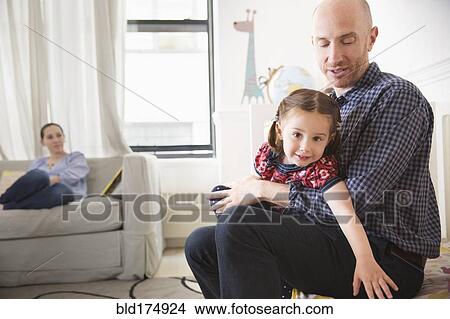 Picture - Father and daughter sitting on bed. Fotosearch