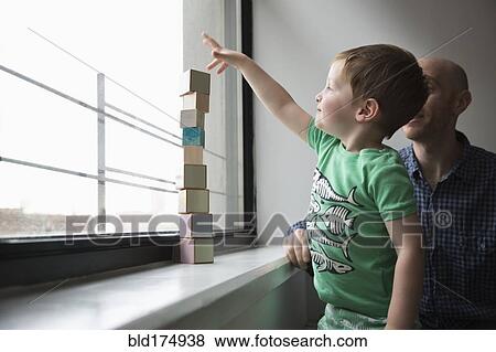 Father and son stacking blocks in window View Large Photo Image Stock Photo - Father and son stacking blocks in window. Fotosearch