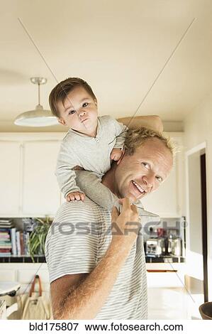 Stock Photo - Father carrying baby son on shoulders. Fotosearch
