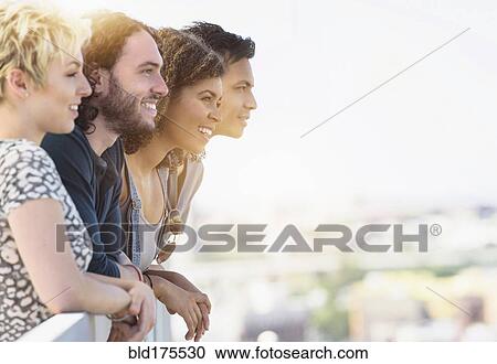 Friends looking at view outdoors View Large Photo Image Stock Image - Friends looking at view outdoors. Fotosearch