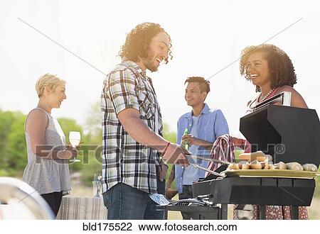 Stock Image - Friends talking at barbecue. Fotosearch