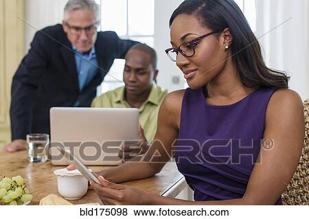 Stock Photo - Friends using laptop at party. Fotosearch