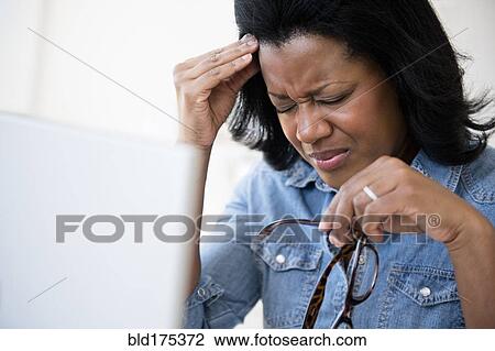 Frustrated Black woman rubbing her forehead View Large Photo Image Stock Image - Frustrated Black woman rubbing her forehead. Fotosearch