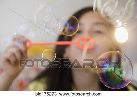 Stock Image - Girl blowing bubbles. Fotosearch