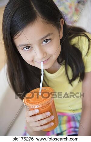Stock Photograph - Girl drinking healthy carrot juice. Fotosearch