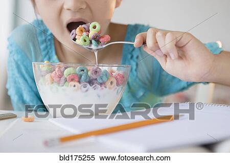 Girl eating bowl of cereal View Large Photo Image Stock Photography - Girl eating bowl of cereal. Fotosearch