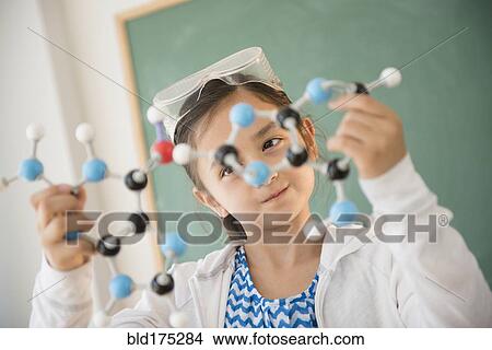 Picture - Girl examining molecular model in science class. Fotosearch
